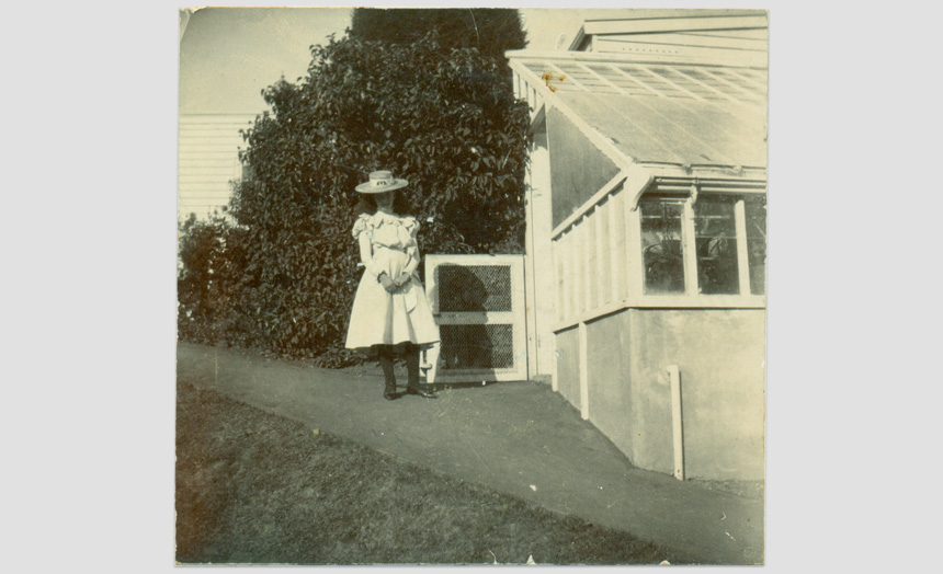 Dorothy Theomin. As a child, taken outside the greenhouse at the first Olveston. Inscribed on back 'Please do not call me till 8 o'clock'.